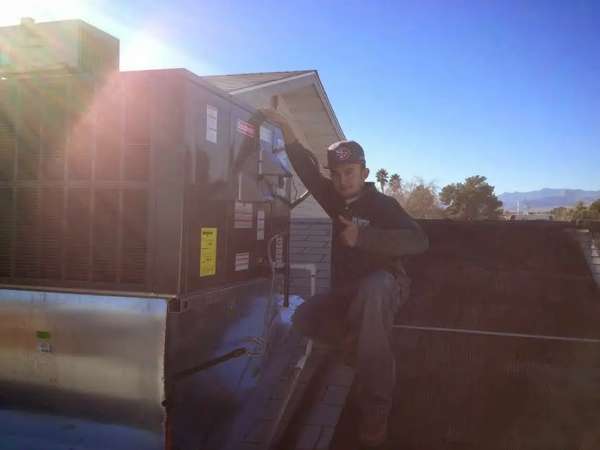 HVAC technician performing HVAC Inspection on a rooftop unit in North Vernon